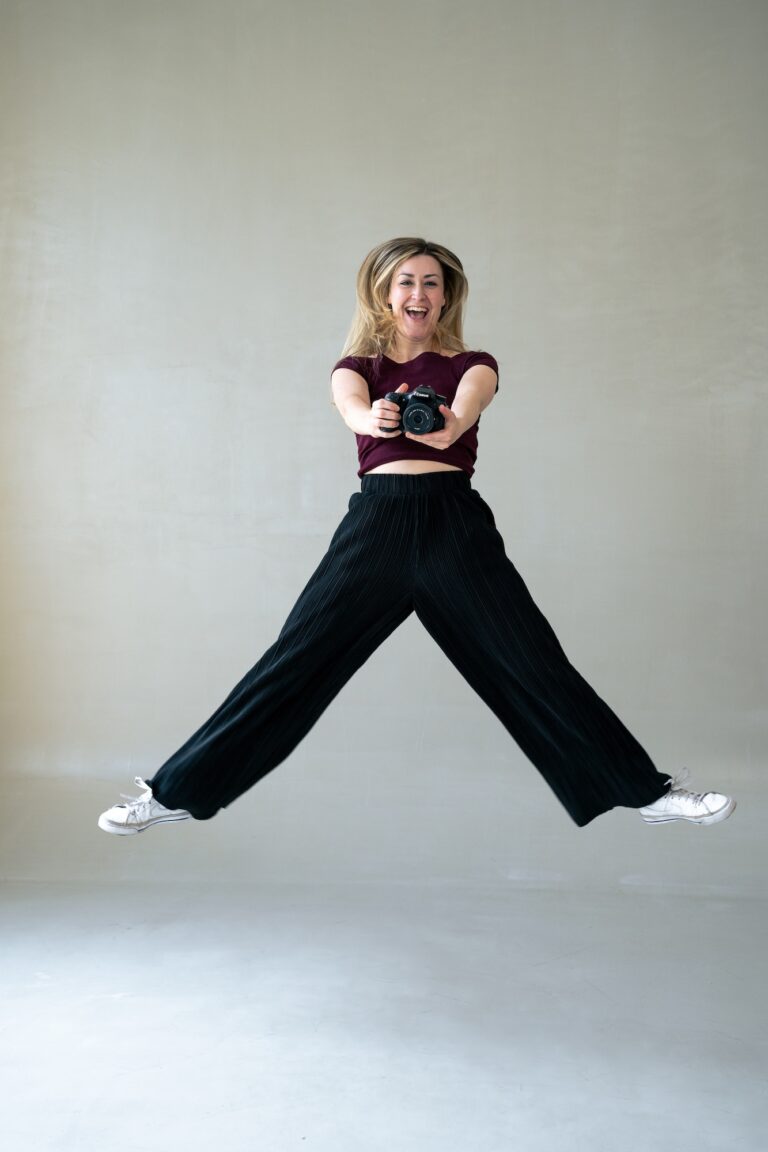 Content Creatorin Theresa Klingohr hüpft mit Kamera fröhlich in die Luft beim Videodreh.